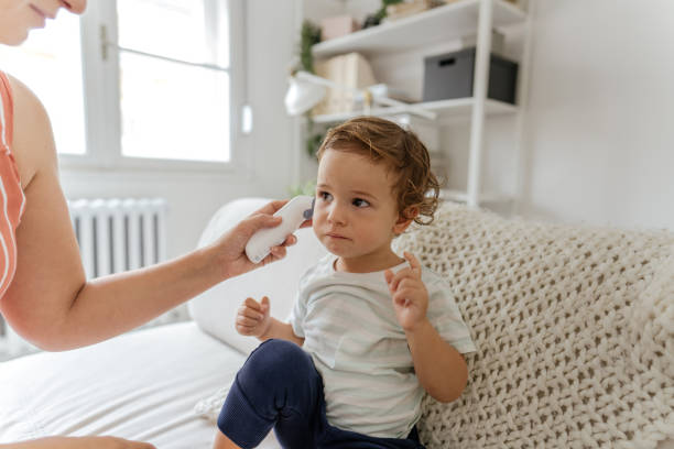 body temperature check with an ear thermometer - young ears imagens e fotografias de stock