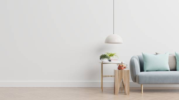 istock Empty living room with blue sofa, plants and table on empty white wall background. 1268593452