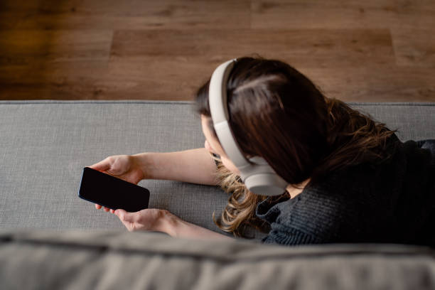 istock Woman listening music on mobile 1268603877