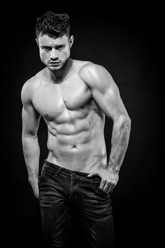 Portrait of Young attractive shirtless man showing his sculptural body. Black and white.