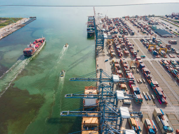 istock Logistics and import,export Container Cargo ship in asia working fro e-commerce business Shot by drone crane bridge in shipyard at sunset , logistic import export and transport industry background 1268613252
