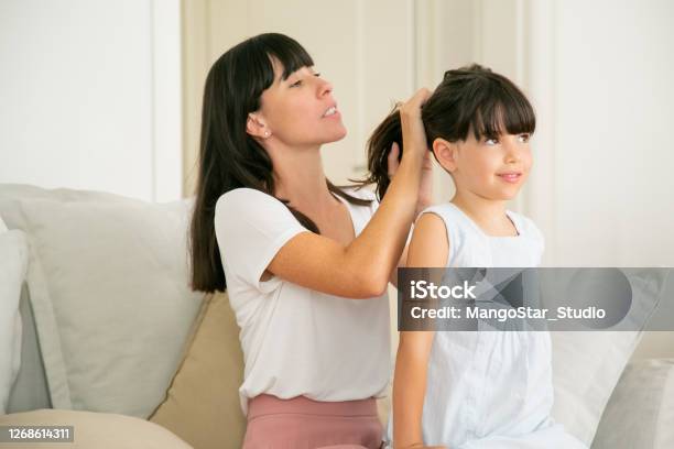 Young Caucasian Mother Holding Hairs Of Her Daughter Stock Photo - Download Image Now