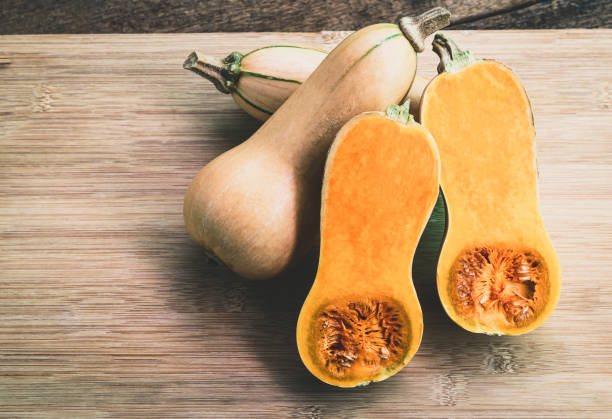 istock Butternut squash sliced on a wooden table. Butternut is a bell-shape fruit with sweet orange-yellow flesh. 1268614548