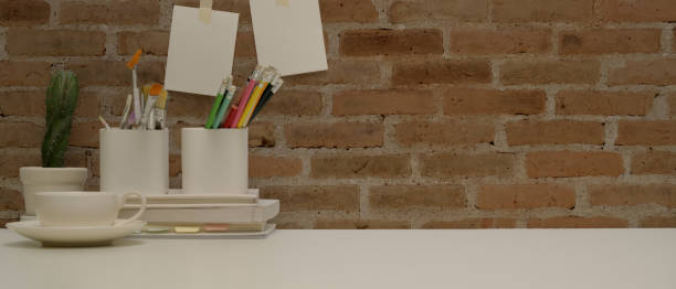 istock Workspace with stationery, paint tools, coffee cup, decoration and copy space on white desk 1268622884
