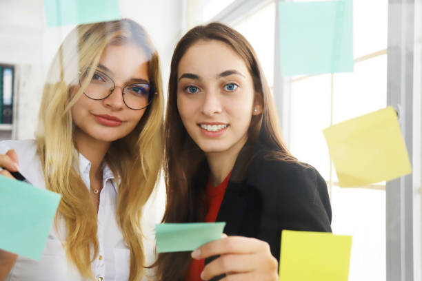 istock Two businesswomen looking at sticky notes 1268623304