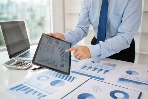 financial business concept. businessman using digital tablet present data of business report and financial statement.