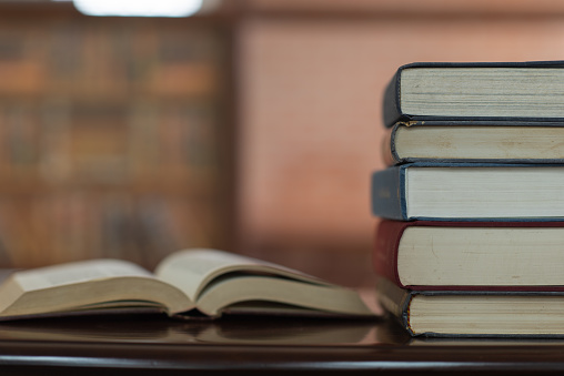 books stack and book open on desk in library. education learning concept.