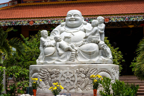 Marble sculpture of the happy Buddha with children in a Buddhist temple in the city of Danang, Vietnam Marble sculpture of the happy Buddha with children in a Buddhist temple in the city of Danang, Vietnam. Close up hotei the god of happiness stock pictures, royalty-free photos & images