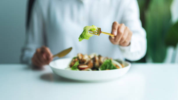 istock a woman eating chicken salad on table in the restaurant 1268629042