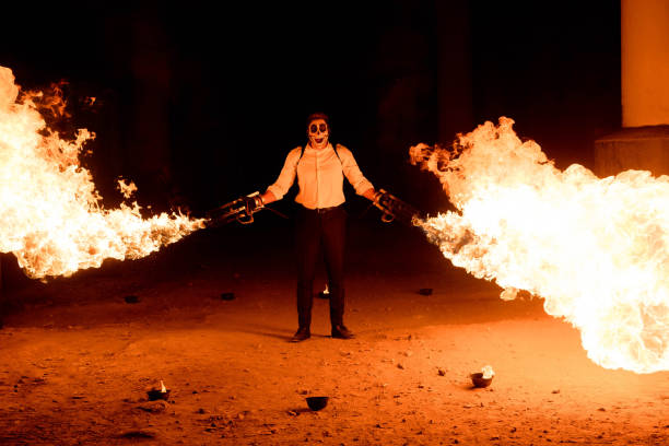 istock Halloween man in costume with flamethrower in his hands. Devil makeup on face 1268631126