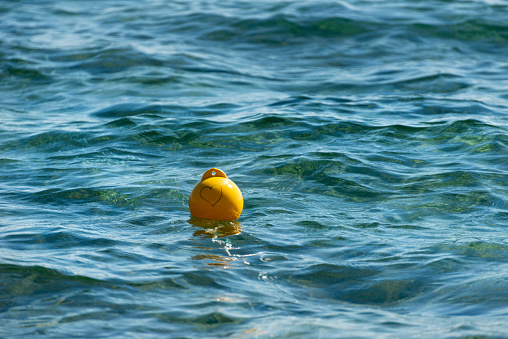 Drawn heart on an yellow buoy in the sea