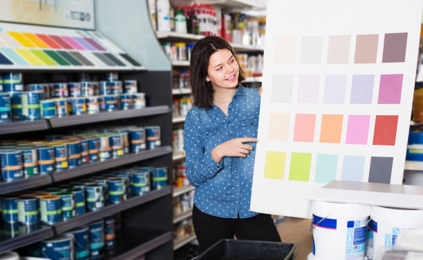 istock female customer examining color scheme variants in paint store 1268634620