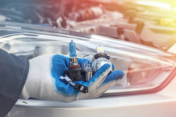 istock Repair man hand installing halogen led bulb for car headlights 1268635152