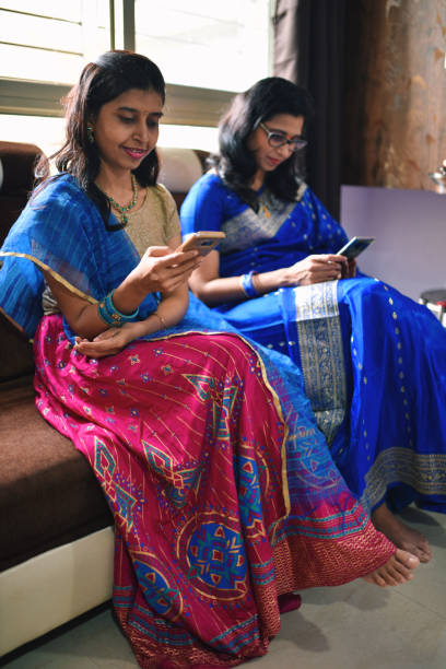 istock Two women in traditional clothing using mobile phone 1268635883