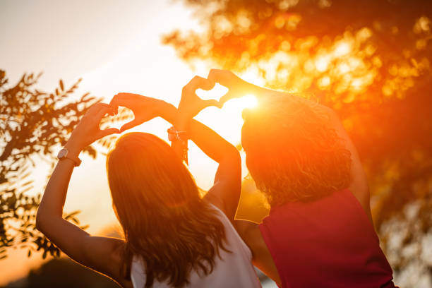 istock Two girls making heart shape symbol with their hands. 1268636020