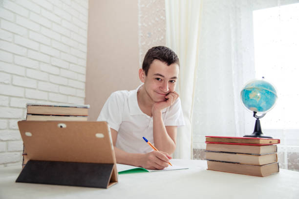 istock teenager does homework at the table in his room 1268640052