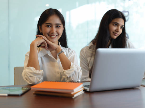 istock Portrait of two female university students in library while doing their assignment 1268640064