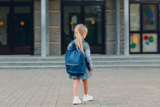 istock Cute little girl with backpack walking back to school 1268640116
