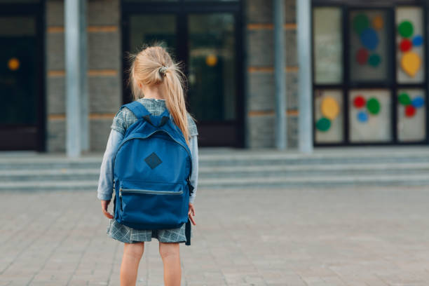 istock Cute little girl with backpack going back to school 1268640119