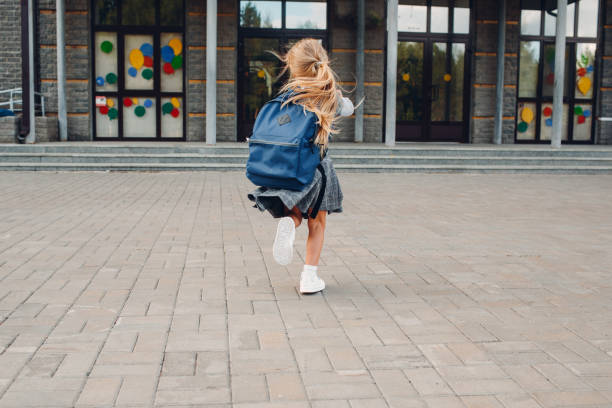 istock Cute little girl with backpack run back to school 1268640122