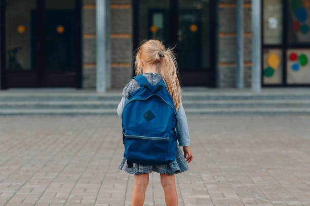 istock Cute little girl with backpack going back to school 1268640123