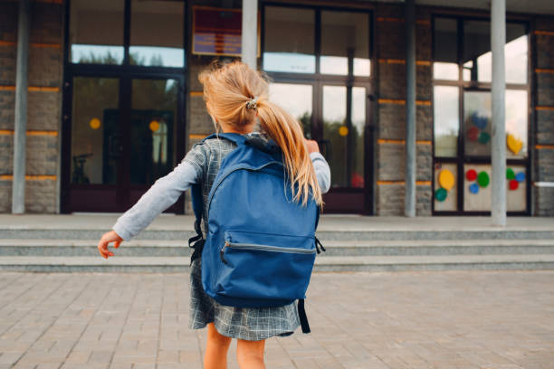 istock Cute little girl with backpack running back to school 1268640126
