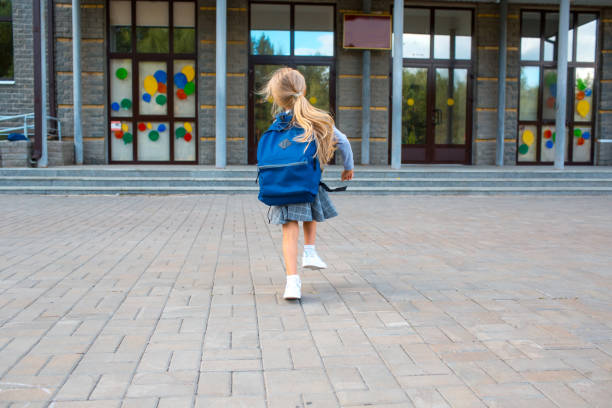 istock Cute little girl with backpack runs back to school 1268640129