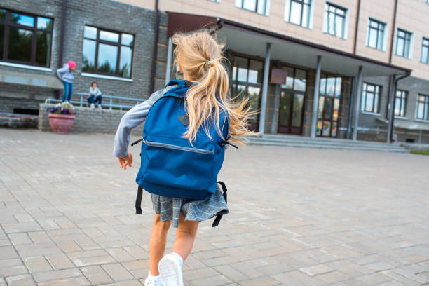 istock Cute little girl with backpack running back to school 1268640132