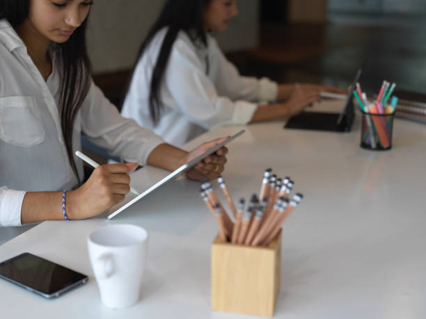 istock Female university students doing assignment with digital devices and stationery 1268640407