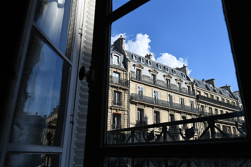 Paris, France-08 16 2020:Parisian apartment facades seen through a window.