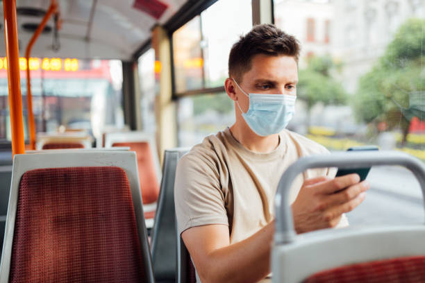 istock Young Caucasian man sitting on a bus, using a smart phone 1268643937