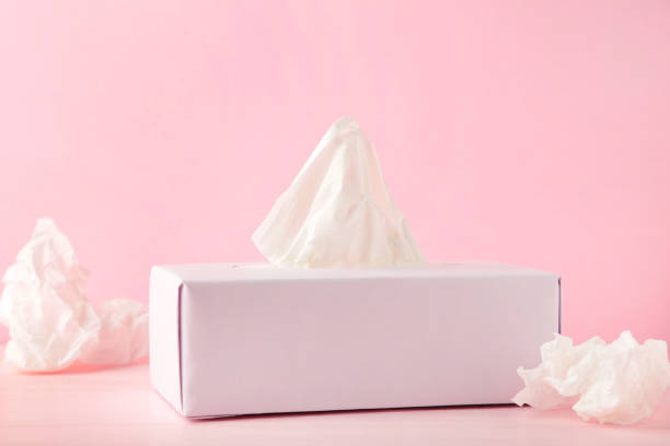 istock Box with paper tissues and used crumpled napkins on pink background 1268646128