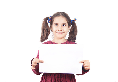 Cropped shot of a cute young girl pointing at a blank card reserved for copyspace