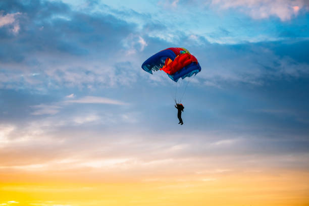 istock Low Angle View Of Person Paragliding Against Sky During Sunset 1268647903