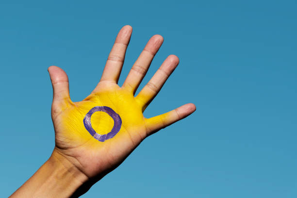 the intersex flag in the palm of the hand stock photo