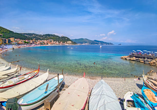 Liguria coast of the city of Noli Italy, landscape of the Ligurian coast at noli, beach with tourists and boats moored on the beach. province of savona stock pictures, royalty-free photos & images