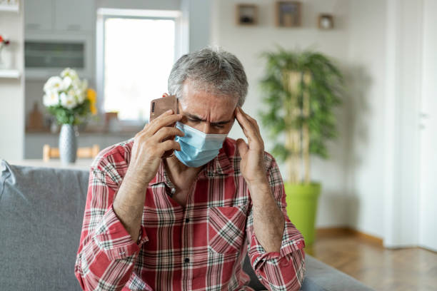 istock Depressed Mature Man With Protective Mask Talking to a Psychiatrist 1268651448