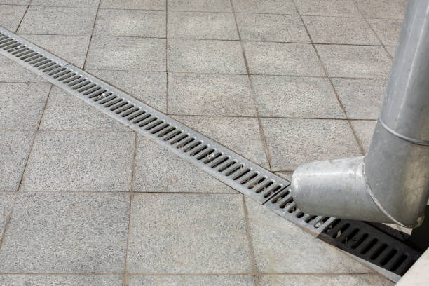 istock an engineering structure a downspout with a drainage grate for drainage of rainwater against a background of a gray stone granite sidewalk from square tiles, nobody. 1268651466