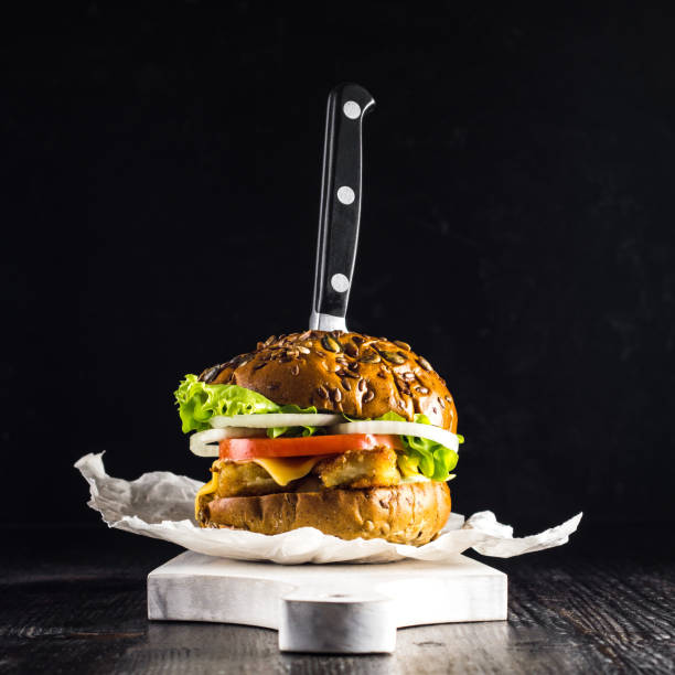 istock Rye Burger with fish fillet on a black background 1268652366