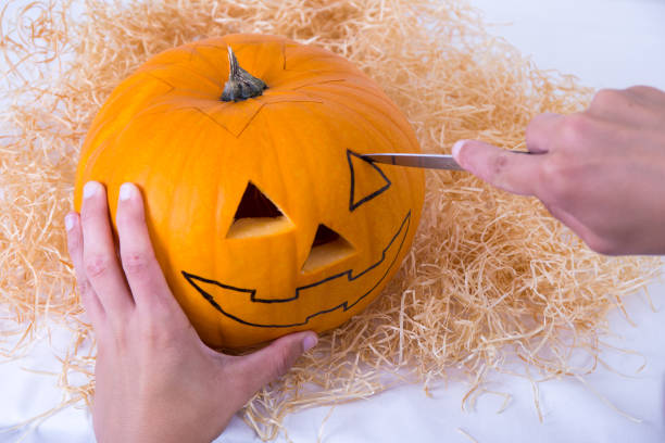 istock male hand making pumpkin Jack O'Lantern for Halloween 1268654624