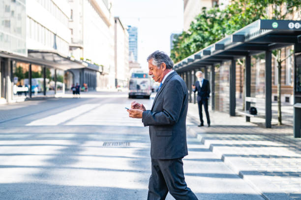 istock Working Senior Executive Crossing Street and Checking Phone 1268655352
