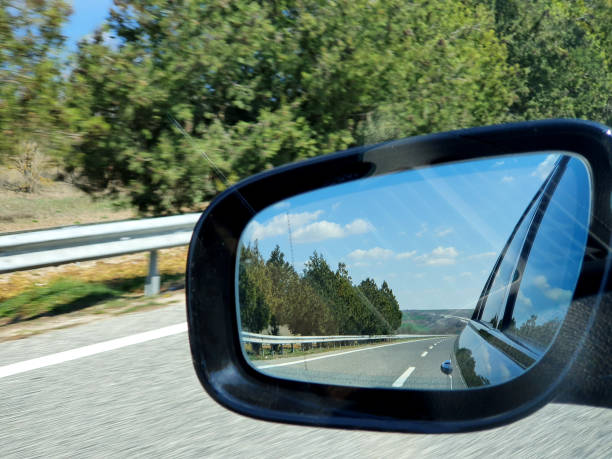 istock Landscape and road reflection in car rearview black mirror. 1268657240