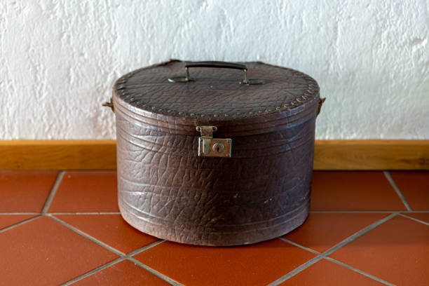 Vintage steamer trunk with leather handles, metal hardware, and zippered mesh compartment lid, showcasing traditional travel luggage craftsmanship from late 19th century era.