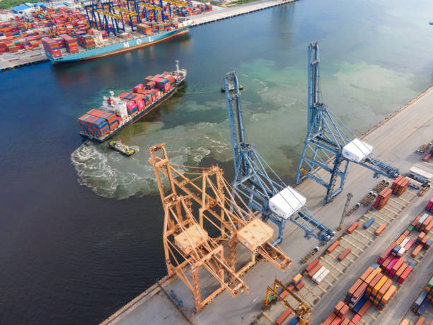 istock Drone shot of a cargo ship working  loading in dock in the Port thailand with crane transportion lowering into position to unload the containers. 1268658101