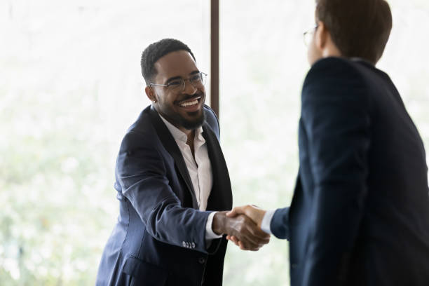 istock Smiling diverse male business partners shaking hands 1268659468