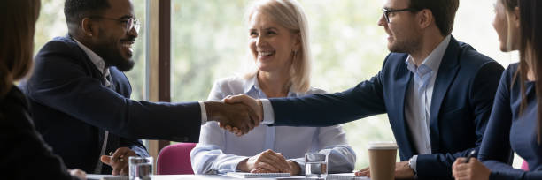 istock Happy diverse male business partners shaking hands 1268659490