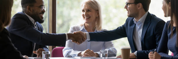 Happy diverse male business partners shaking hands Banner image. African and caucasian millennial businessmen colleagues shaking hands on meeting in office, diverse enterpreneurs striking good deal, multiethnic teammates succeed in common project work business development banner stock pictures, royalty-free photos & images
