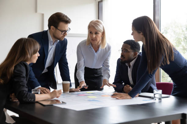 istock Senior female business trainer explaining project details to young trainees 1268659509