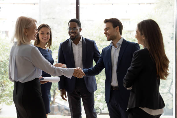 istock Young team leader greeting elder female employee at lunch break 1268659520