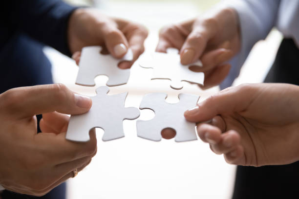 istock Diverse businesspeople collecting puzzle showing successful teamwork 1268659538
